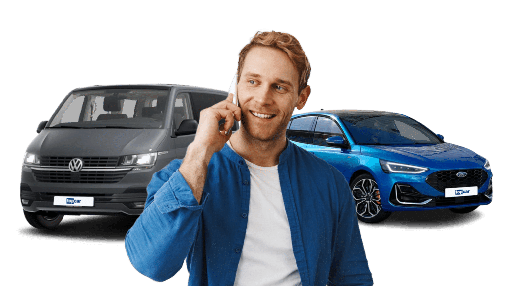 ein blonder mann mit weißen shirt und blauem hemd telefoniert, im hintergrund steh ein grauer bus der marke vw und ein blauer pkw der marke ford